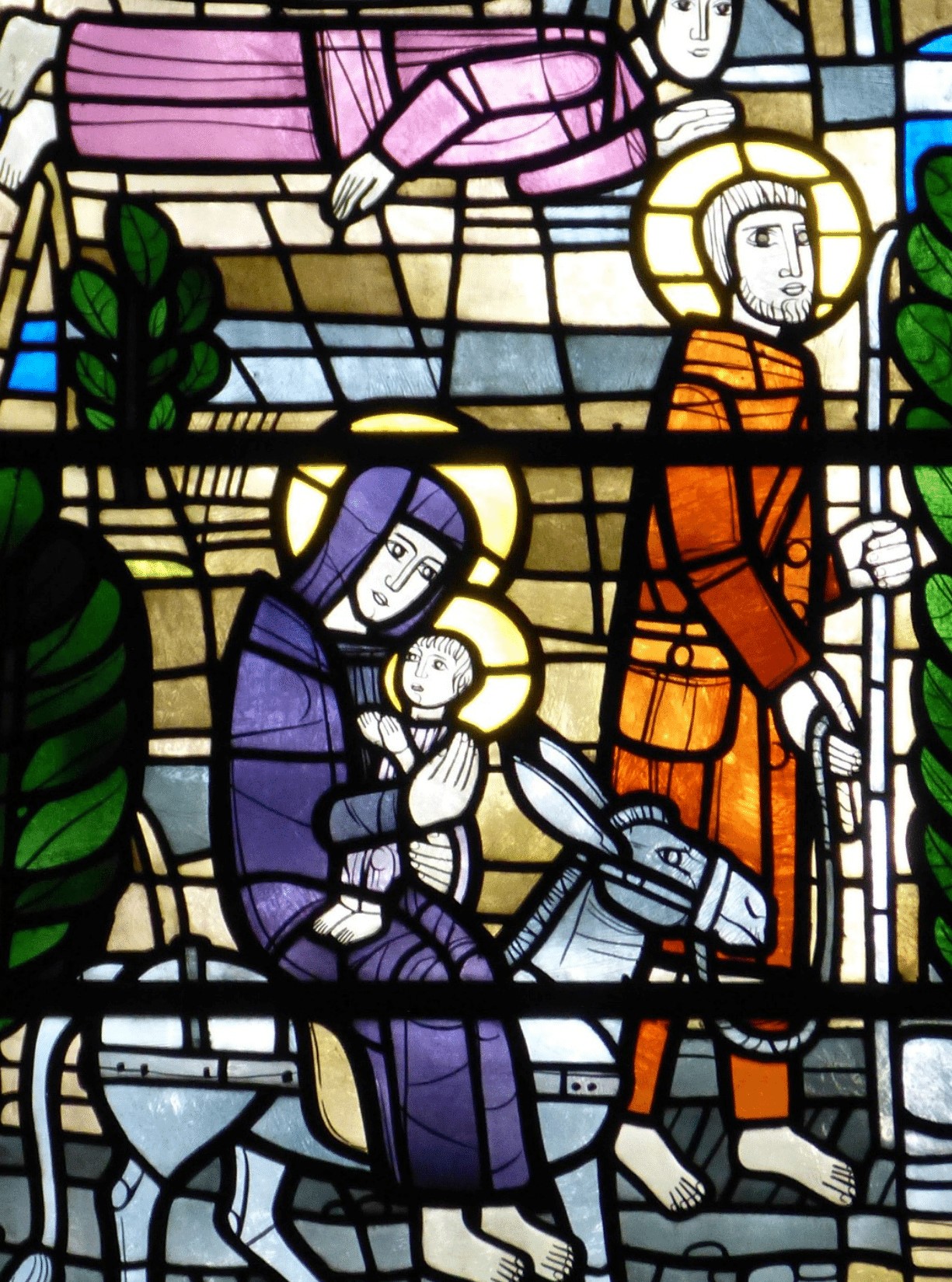 The Holy Family with an angel overhead depicted in stained glass